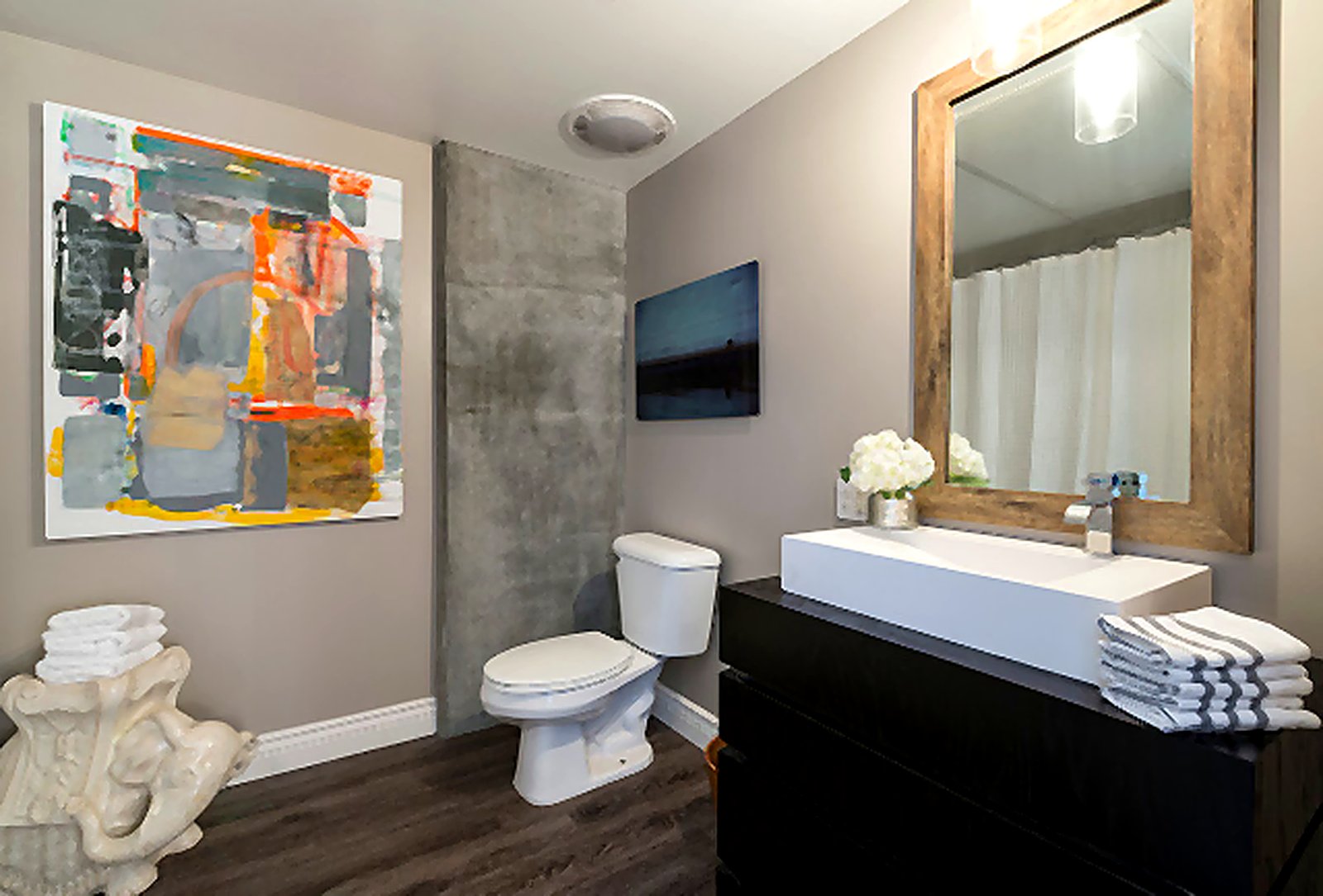 Downtown LA furnished apartment bathroom with abstract art, reclaimed wood mirror, and modern vanity