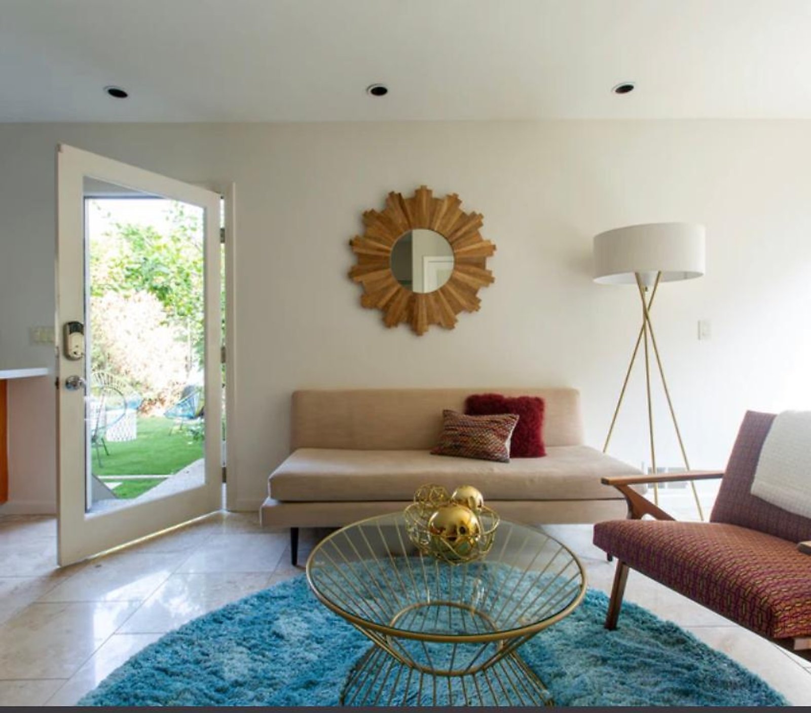 West Hollywood furnished rental living room with sunburst mirror and garden access